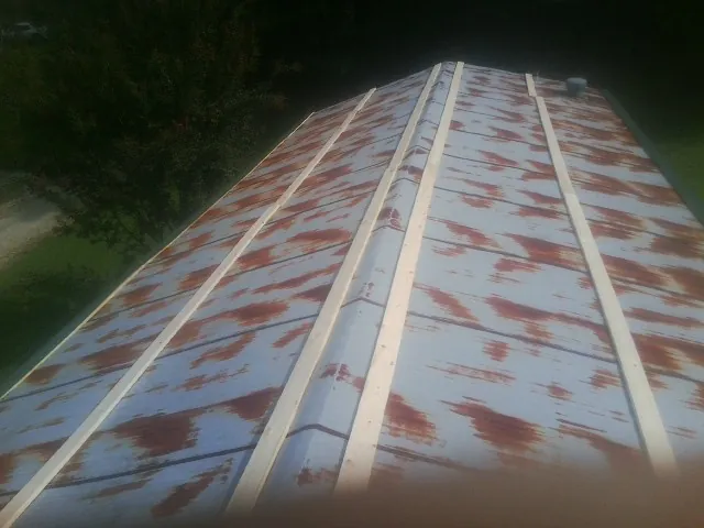 Rusted metal roof panels with new wood purlins before replacement — Storm Damage Roof Repair in Philpot by Roofing Brothers
